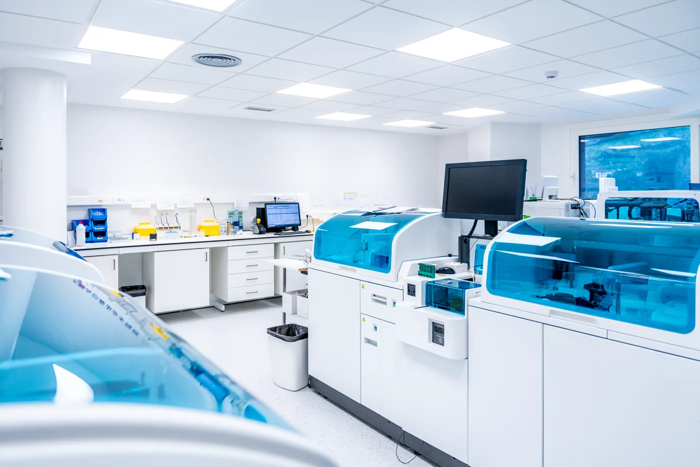 Laboratório moderno com equipamentos de análise e bancadas brancas